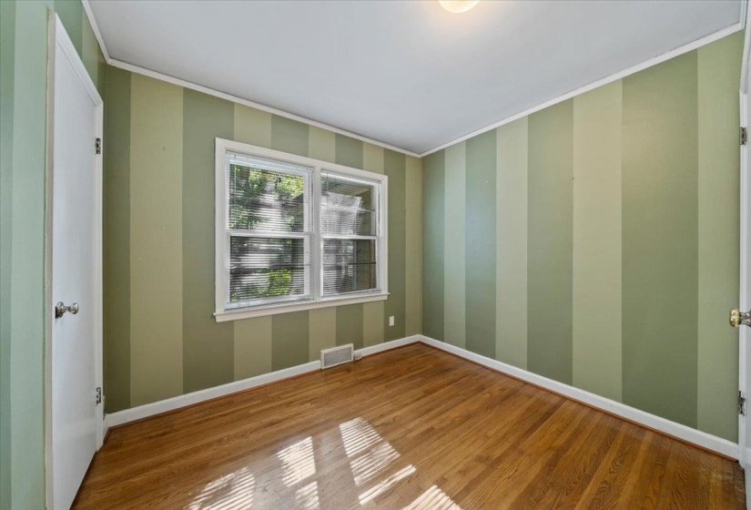 Bedroom with molding and wood finished floors