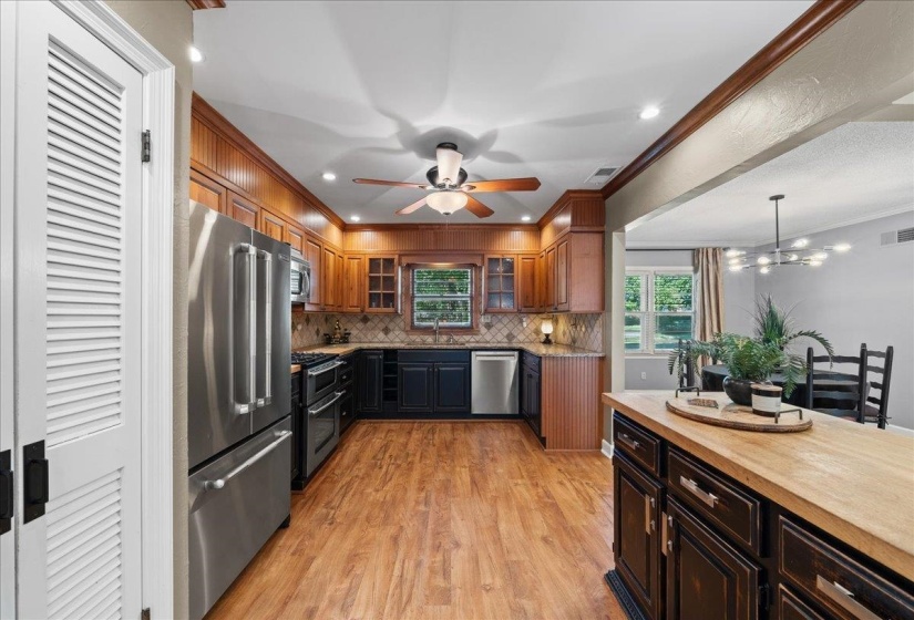 Kitchen featuring crown molding, stainless steel appliances, with light wood-style floors