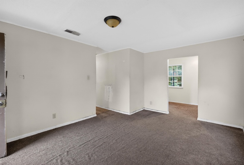 Carpeted interior space featuring light-colored walls, white baseboards, and a ceiling-mounted light fixture
