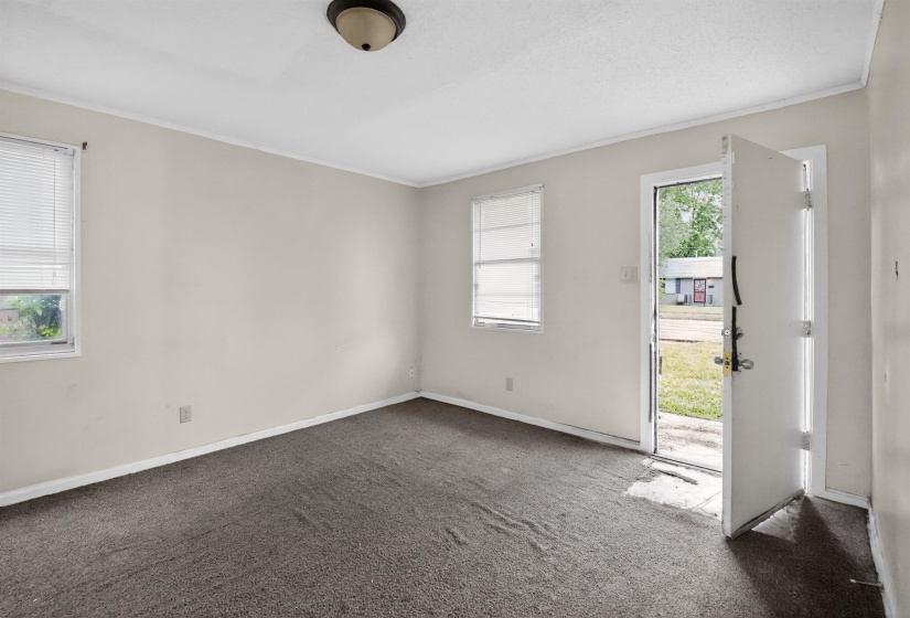 Interior room featuring light-colored walls and dark carpet flooring