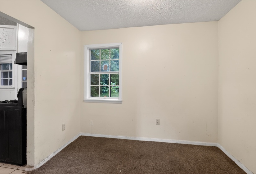 Room featuring neutral wall tones, brown carpet, and a window with white trim