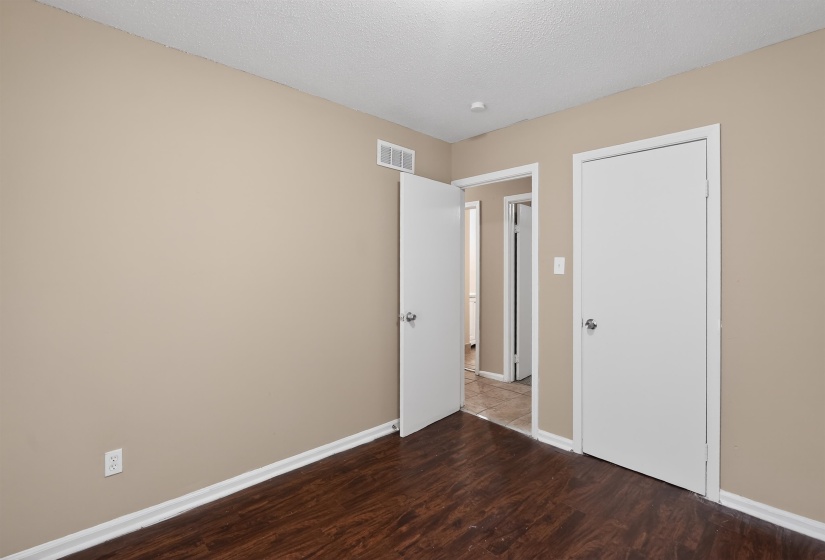 Room featuring wood-finish flooring, neutral wall tones, and white trim