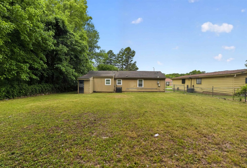 Expansive rear yard featuring green space and mature perimeter trees
