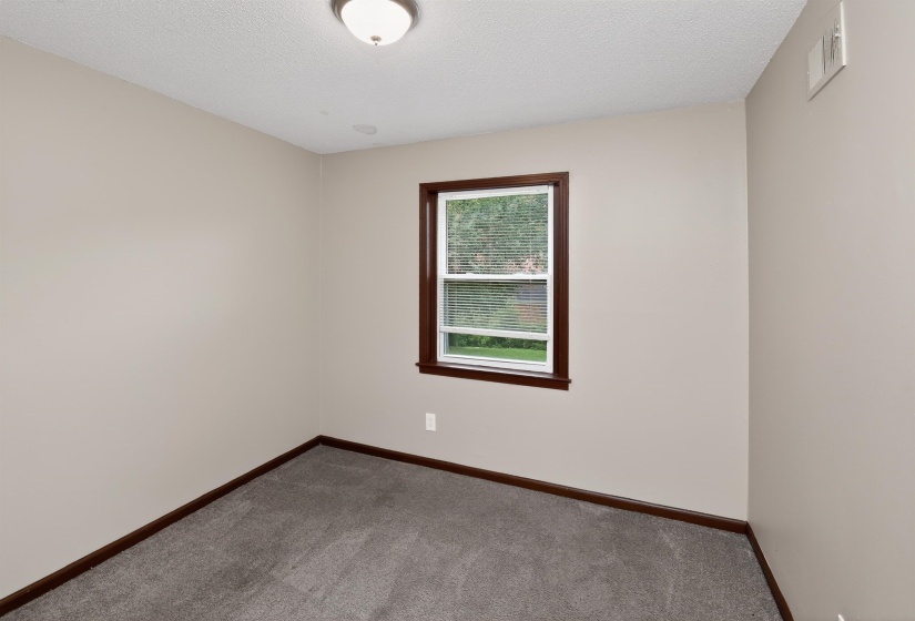 Neutral-toned walls complement plush grey carpeting