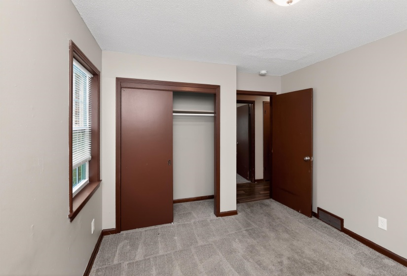 Room featuring light gray wall paint, gray carpet, dark brown trim, and a sliding closet door