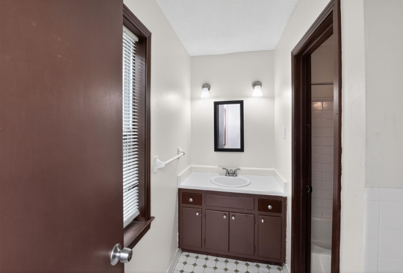 Bathroom featuring a brown vanity with a white countertop and integrated sink
