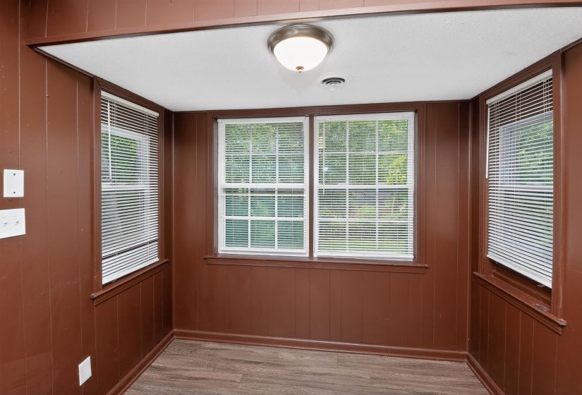 Room featuring wood-finish flooring and rich brown wall paneling