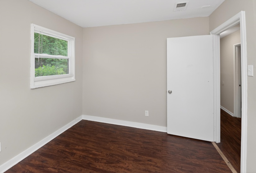 Bedroom with wood-finish flooring and light gray wall paint