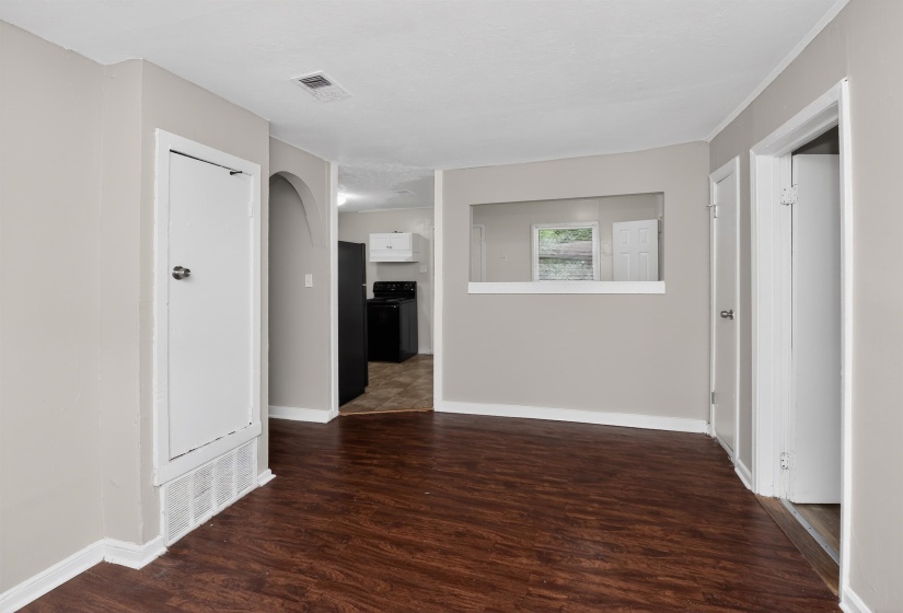 Interior space featuring wood-finish flooring, light neutral wall paint, and white trim