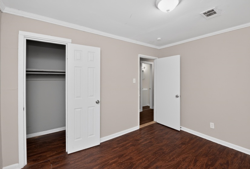 Bedroom featuring wood-finish flooring, neutral wall paint, and white trim
