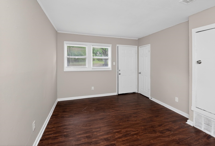Interior room featuring wood-finish flooring, light neutral wall paint, and white trim