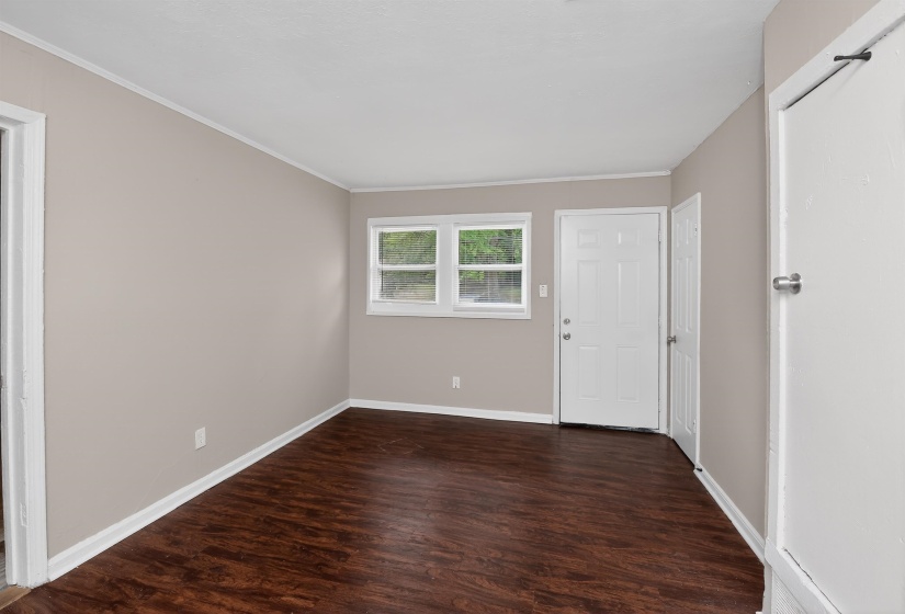 Interior room featuring wood-finish flooring, two windows, and neutral-toned wall paint