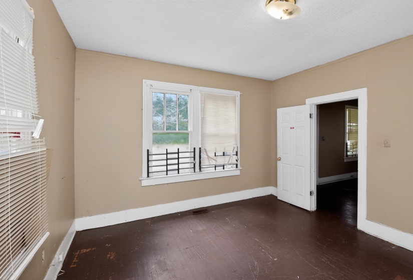 Interior room featuring dark wood flooring, neutral tone walls, and white trim