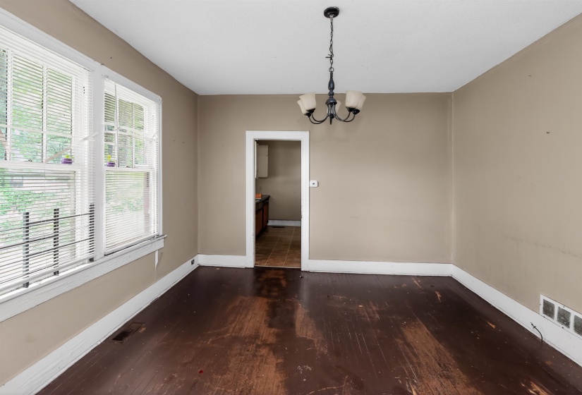 Interior room featuring dark wood-finish flooring, light tan painted walls, and white trim