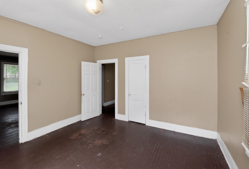 Interior room featuring neutral wall tones, white trim, and dark wood-finish flooring
