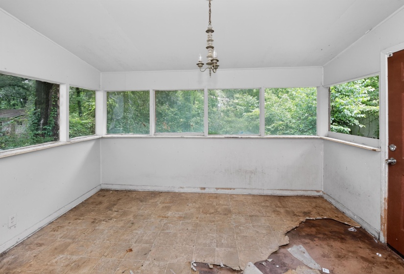 Sunroom featuring multiple windows, a ceiling-mounted light fixture, and an exterior door
