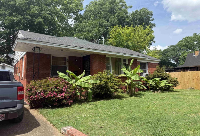Brick exterior with a gabled roof and lush front landscaping