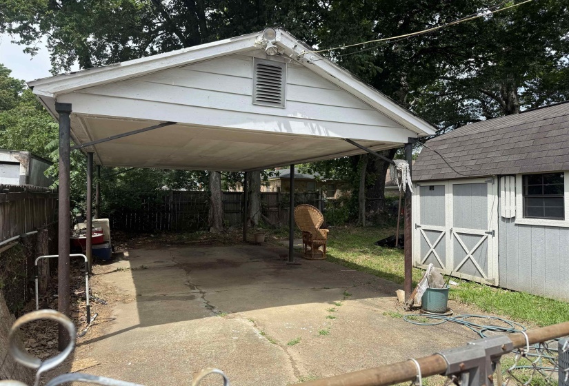 Concrete driveway leading to a covered carport, offering sheltered parking