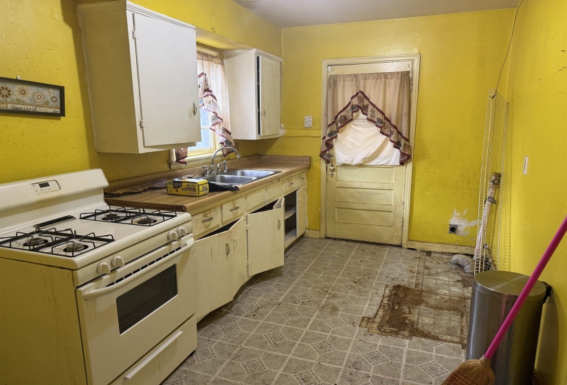 Kitchen featuring a gas range, dual basin sink, and wood-finish countertops