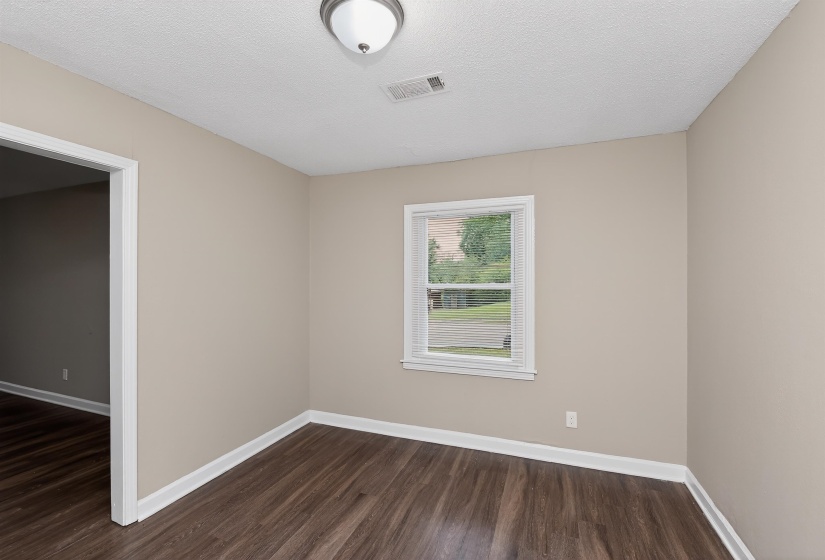 Interior room featuring wood-finish flooring, neutral wall paint, and white trim