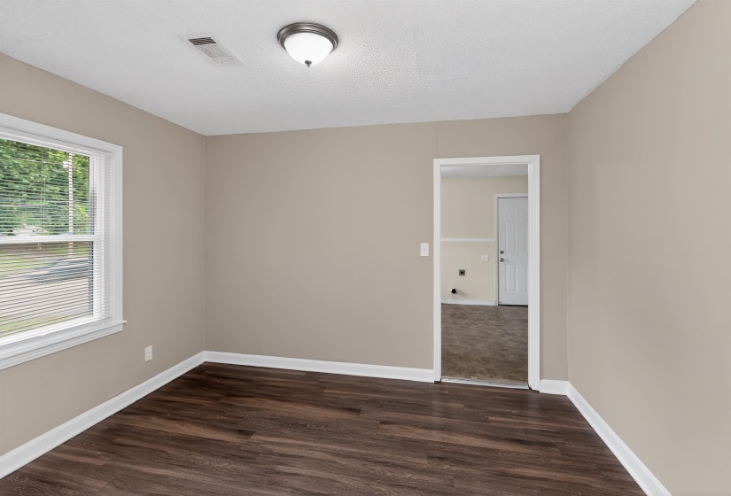 Interior room featuring wood-finish flooring, neutral wall tones, and white trim