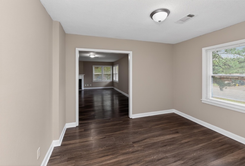Interior space featuring wood-finish flooring, neutral wall paint, white trim, and a semi-flush mount ceiling light fixture