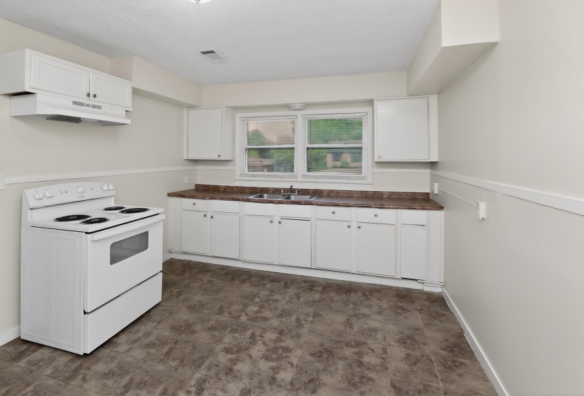 Kitchen featuring white cabinetry, a white electric range, and a dual-basin stainless steel sink