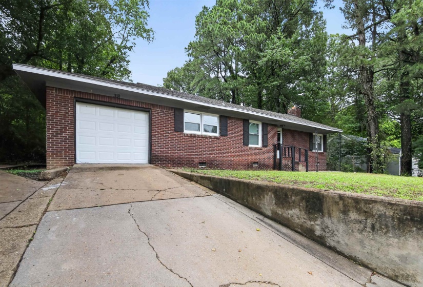 Brick ranch-style home featuring a prominent white garage door