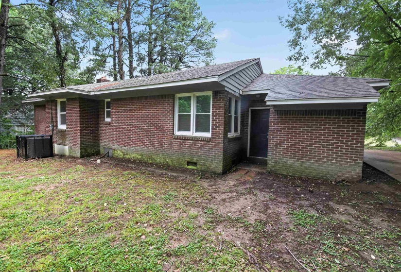 Brick exterior with multiple windows and a shingled roof