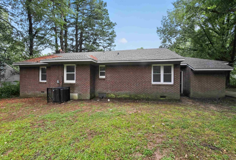 Brick exterior with multiple windows and a shingle roof
