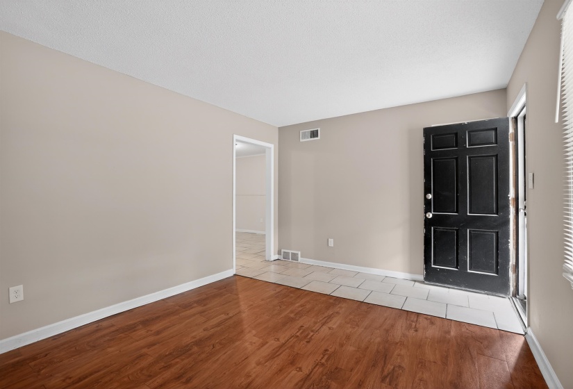 Entryway featuring wood-finish flooring, light neutral wall paint, and white baseboards