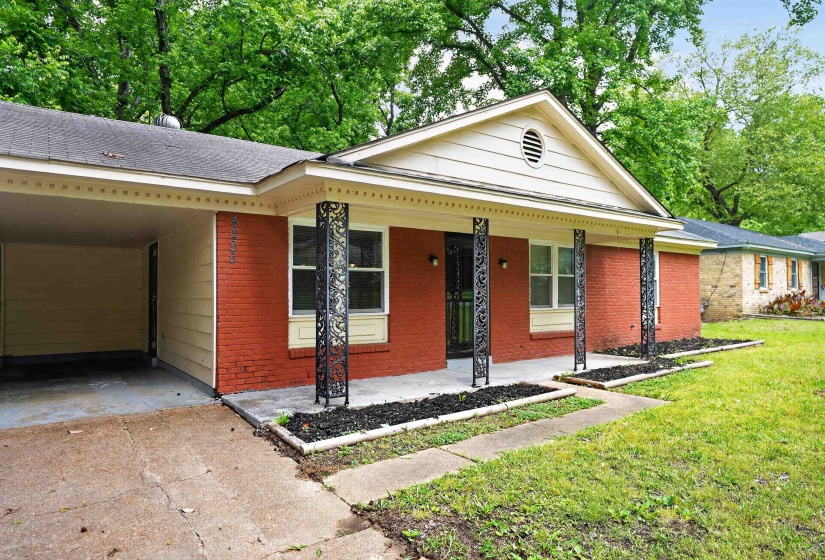 Brick exterior featuring a covered front porch with decorative metal columns