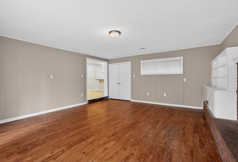 Spacious interior with wood-finish flooring, neutral board and batten walls, and white trim