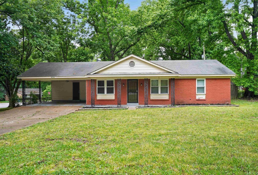 Red brick exterior with a front-facing gable, carport, and manicured front lawn