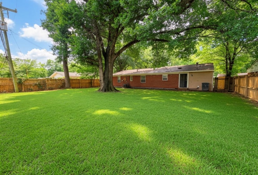 Expansive green lawn with mature shade trees