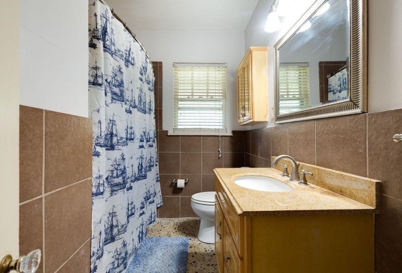 Bathroom featuring a vanity with an integrated sink, a speckled countertop, and a built-in wall cabinet