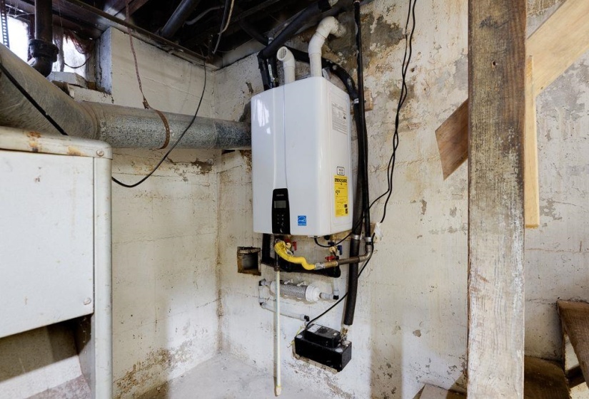 Tankless water heater installation against a concrete wall