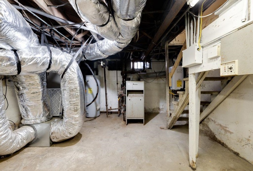 Basement utility area featuring exposed ductwork, concrete flooring, and an accessible water heater