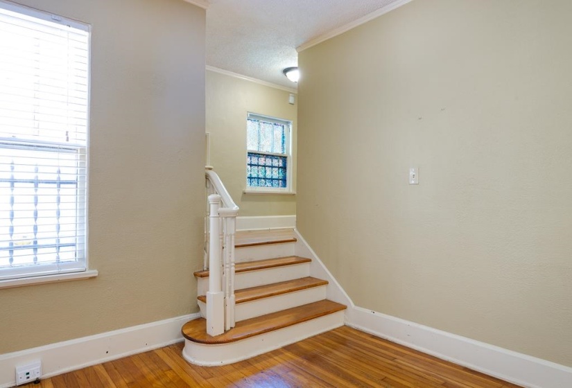 Entryway featuring wood-finish flooring and a white painted staircase with a wood-finish tread