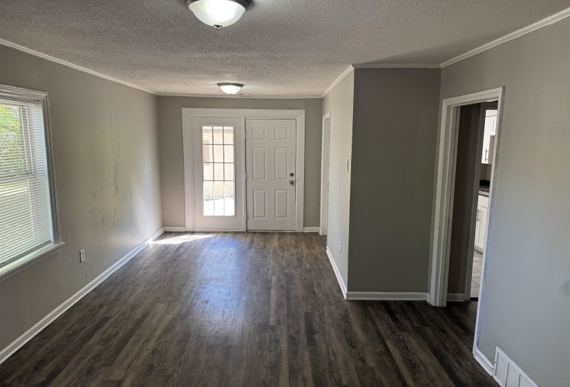 Open-concept interior featuring wood-finish flooring, light gray wall paint, and white trim throughout