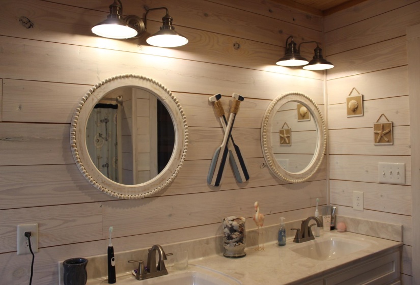 Bathroom featuring wood walls and double vanity