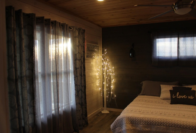 Bedroom featuring wooden ceiling, wood finished floors, and wood walls
