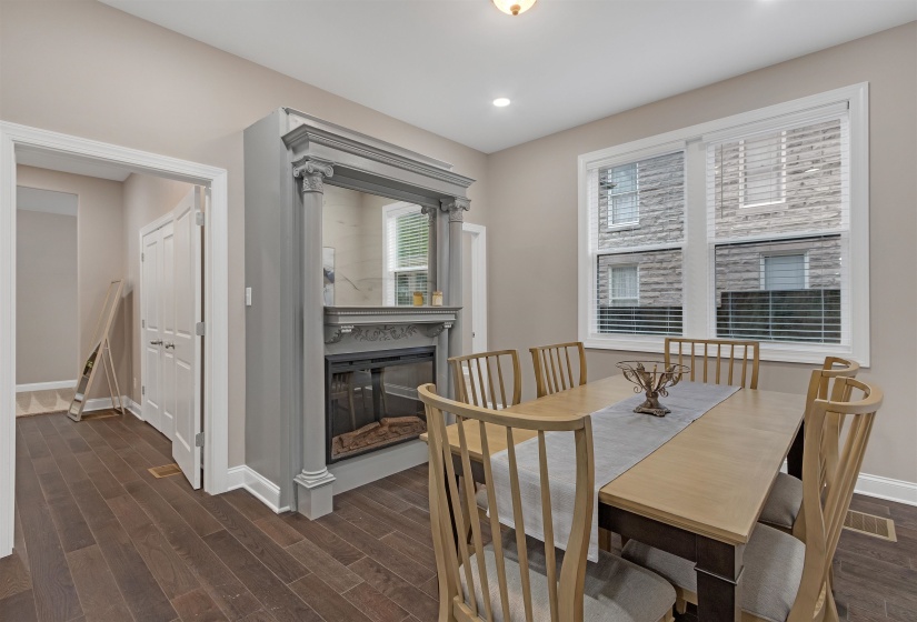 Dining area with a high end fireplace and dark hardwood / wood-style flooring