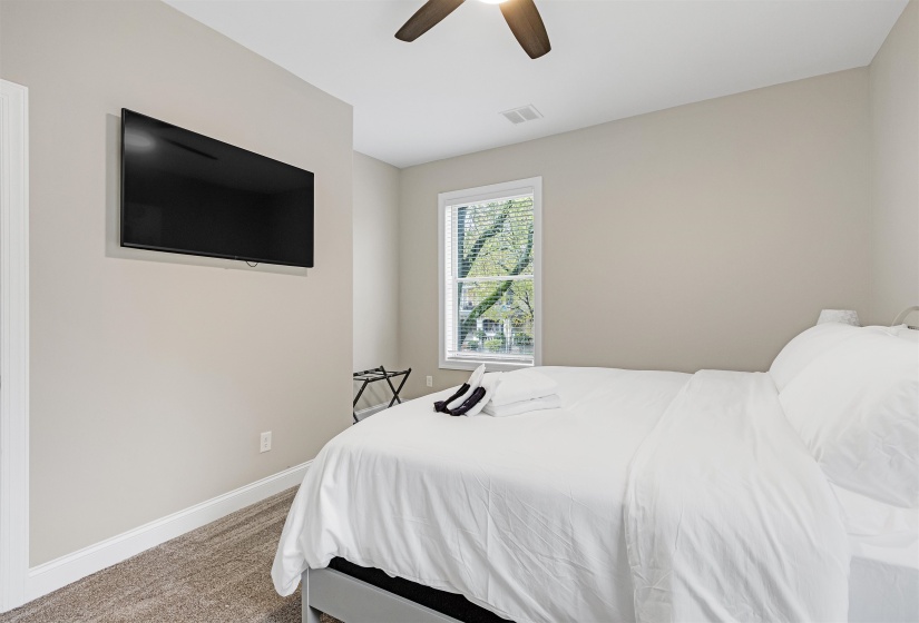 Carpeted bedroom featuring ceiling fan