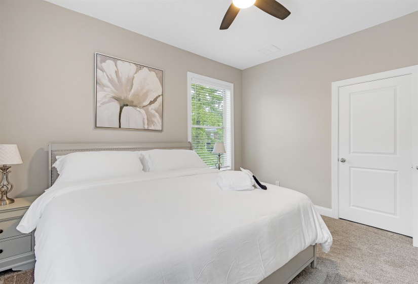 Carpeted bedroom featuring ceiling fan