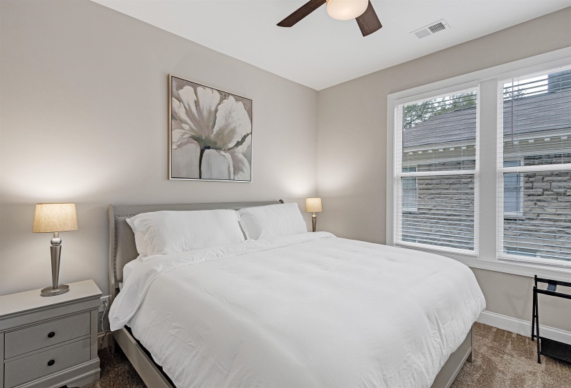 Carpeted bedroom featuring ceiling fan