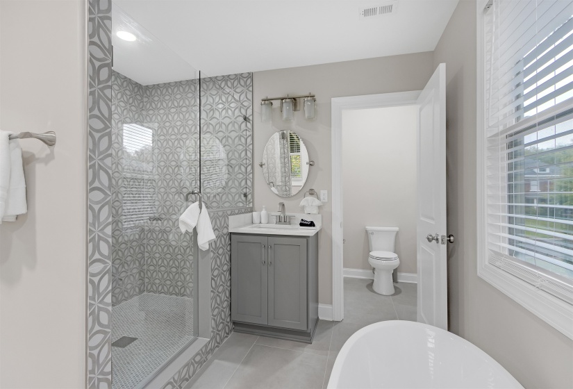 Full bathroom with tile patterned floors, vanity, a healthy amount of sunlight, and plus walk in shower