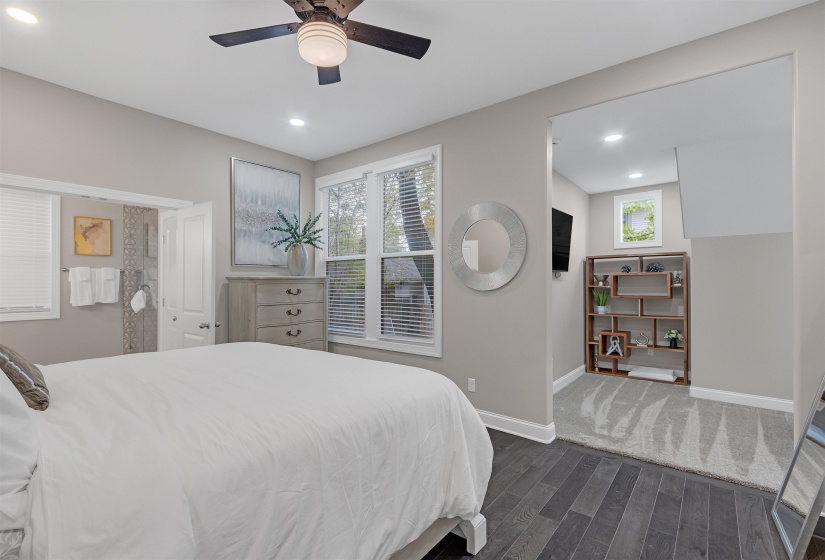 Bedroom with ceiling fan, dark wood-type flooring, and multiple windows