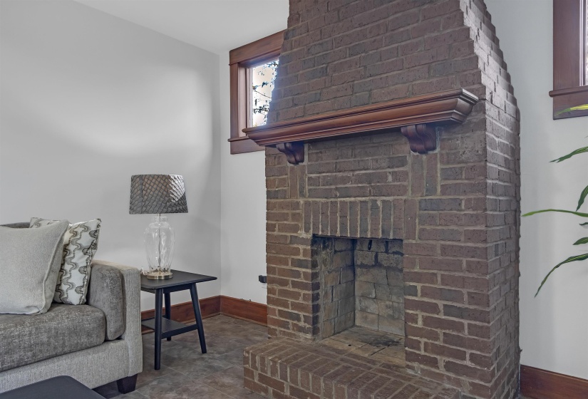 Living room featuring tile patterned flooring and a brick fireplace