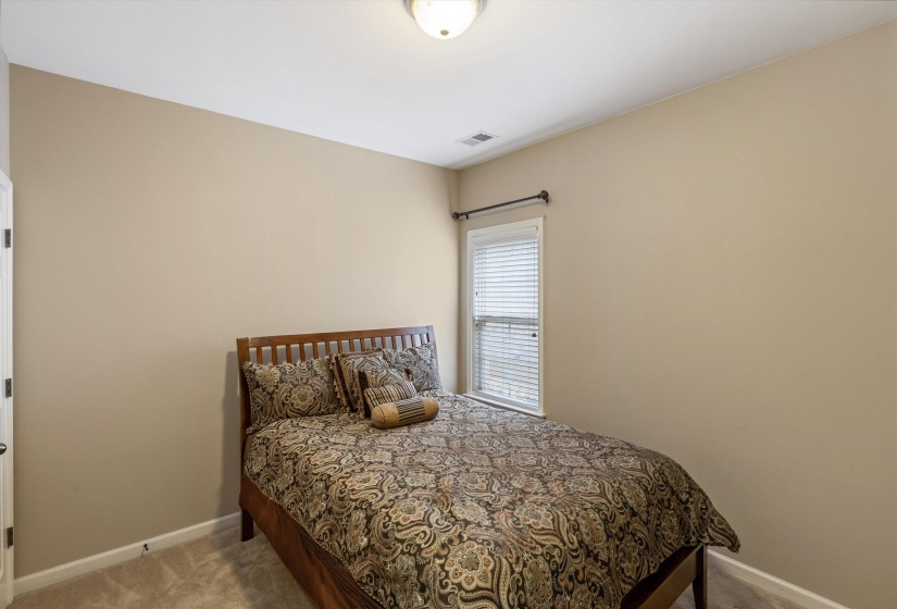 Carpeted room with neutral tone walls and a single window with blinds